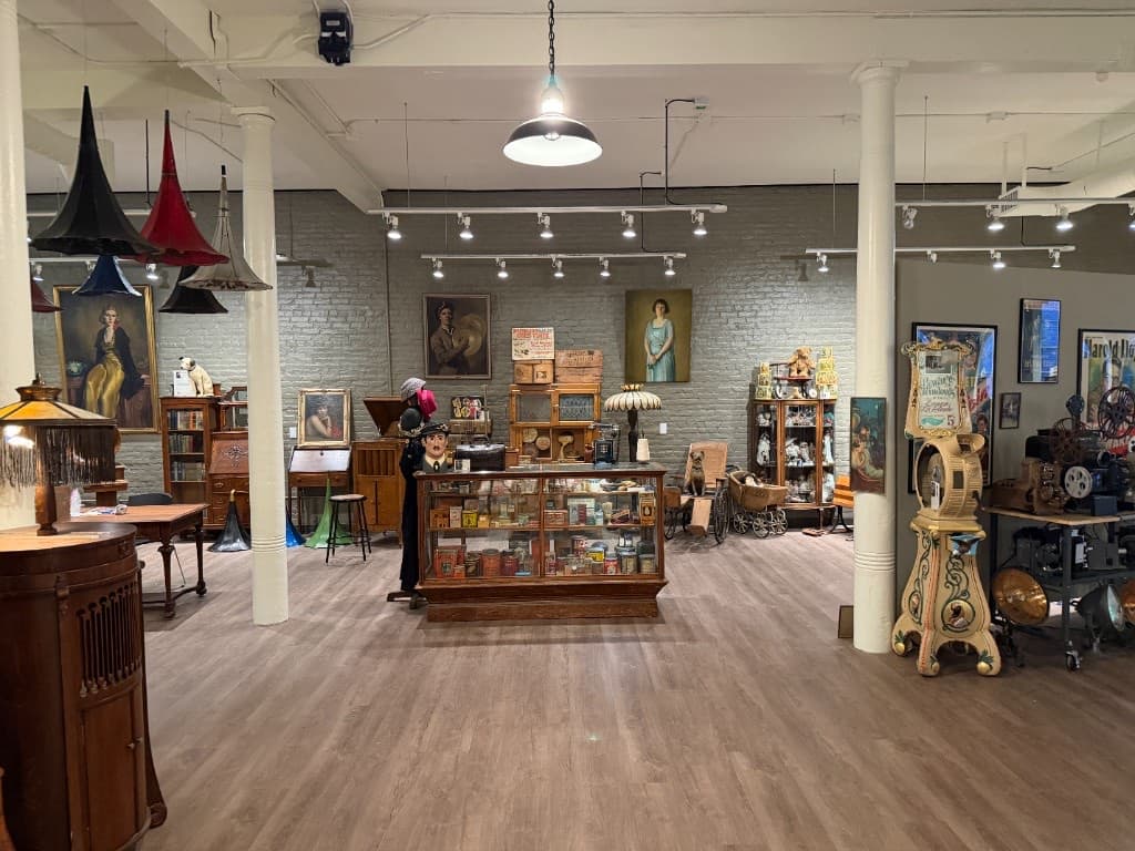 The main exhibition room with paintings, display cases, and film projectors.